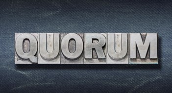 quorum word made from metallic letterpress on dark jeans background"r"n