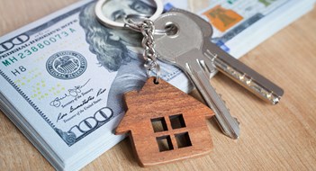 Real estate investing concept. American dollar, cash or housing. Keys close-up