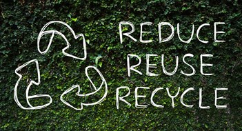 Hand drawing Reduce - Reuse - Recycle symbol with green nature background.