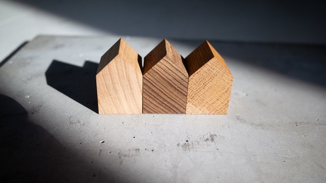 Group of similar wooden tiny toy houses. Wooden models of buildings as conceptual images for real estate topics.